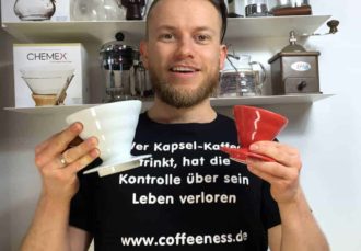Arne posa con dos filtros de café de porcelana Hario en las manos