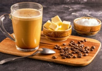 Taza de bulletproof coffee junto a todos los ingredientes