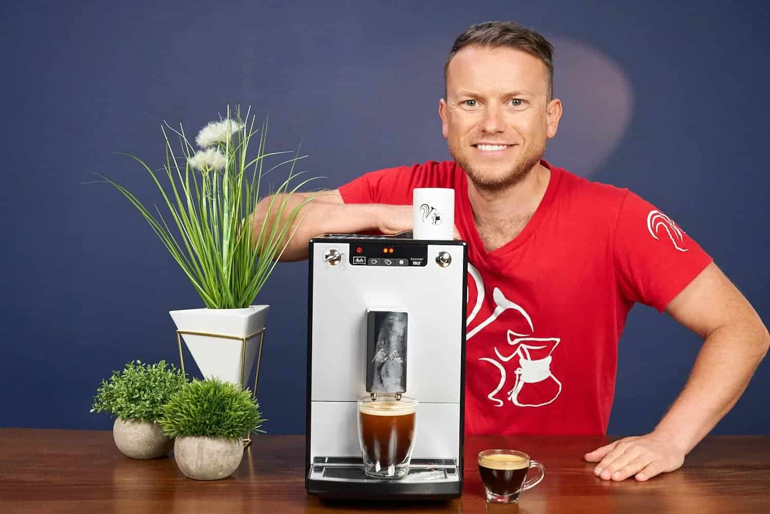 Arne posa con la cafetera superautomática Melitta Caffeo Solo y algunas bebidas