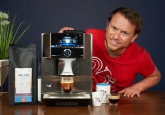 Arne posa con la cafetera superautomática Siemens EQ 9 preparando un expreso y con el café de Coffeeness
