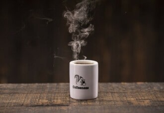 Café caliente en taza corporativa de Coffeeness