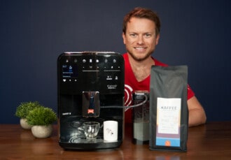 Arne posa con la cafetera superautomática Melitta Caffeo Barista TS Smart y el café de Coffeeness