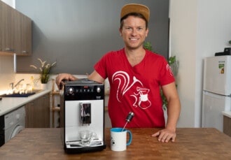 Arne posa sonriente con la cafetera superautomática Melitta Purista