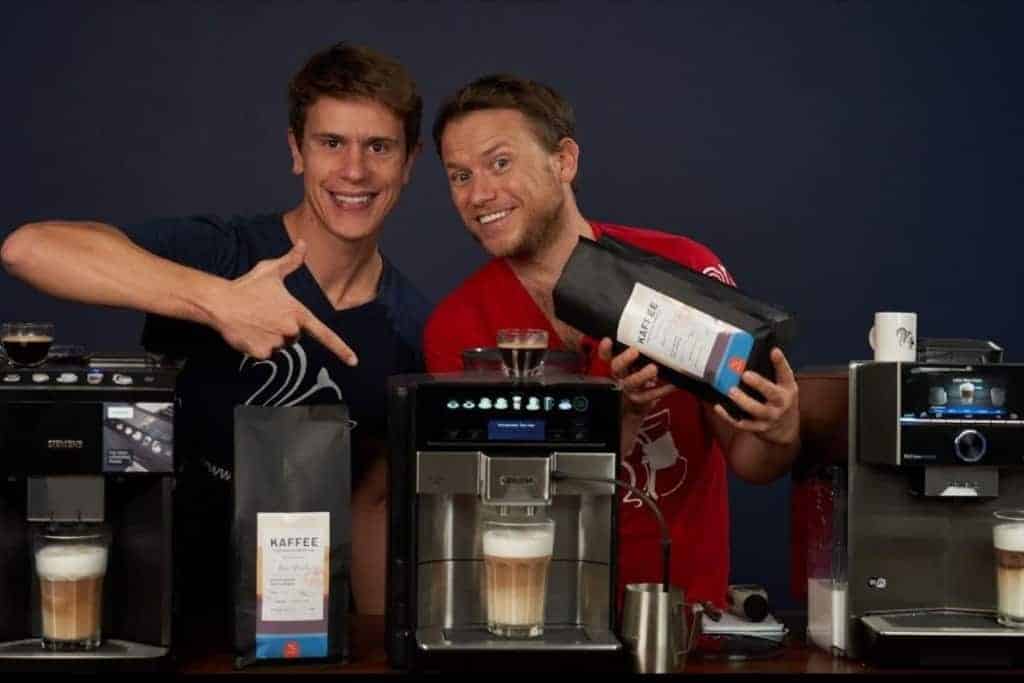 Comparativa de cafeteras superautomáticas Siemens: Mauricio y Arne posan sonrientes con dos paquetes de café de Coffeeness
