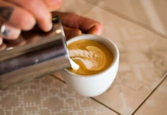 Haciendo latte art con un capuchino en la prueba de granos de expreso de Flying Roasters