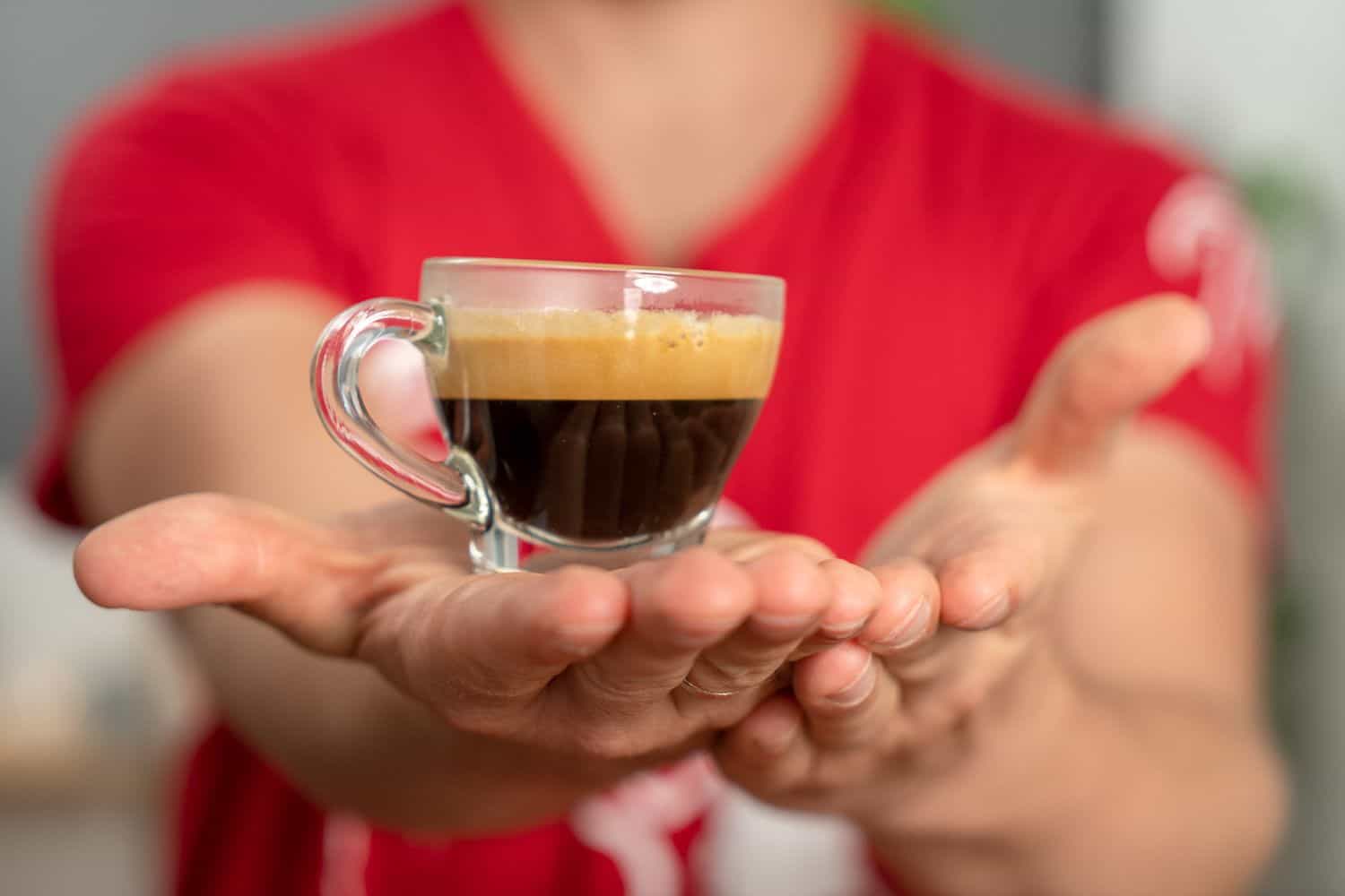 Arne tient une tasse expresso dans la paume de sa main