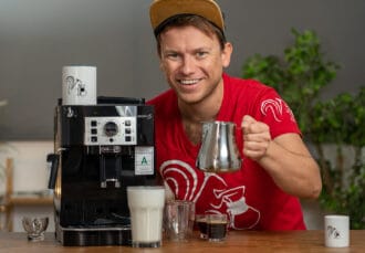 delonghi ecam 22110b arne pose en souriant avec un pot à lait à la main