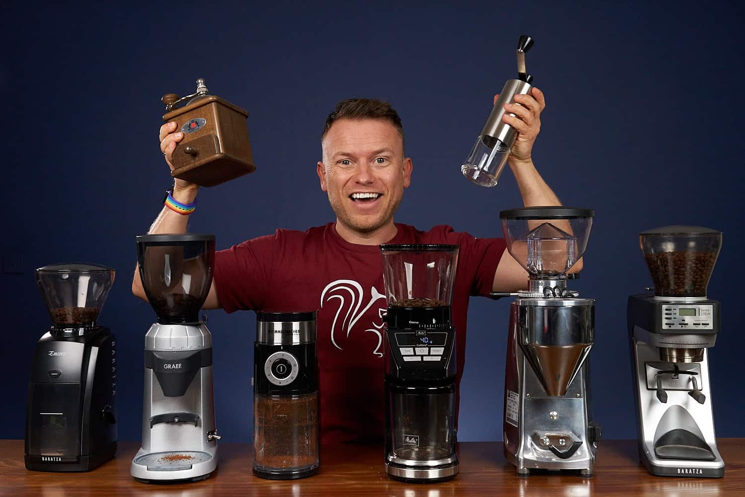 Arne posa sonriente con 6 molinillos de café y sostiene 2 en las manos