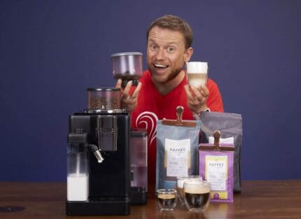 Arne posa sonriente con la cafetera superautomática DeLonghi Rivelia